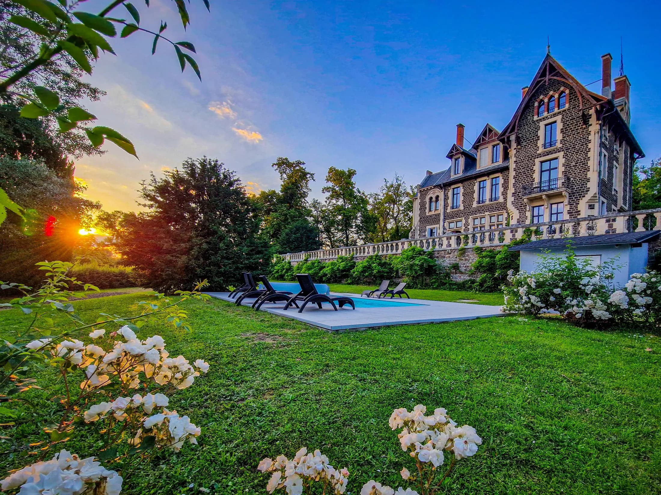 Le Manoir des Rêves Sauvages au coucher du soleil, sa piscine et son parc